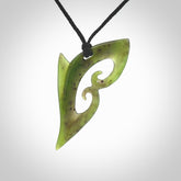 This photo shows a koru pendant carved from New Zealand Jade. The artist, Shaun Gardiner, has carved this beautifully. We provide this piece with an adjustable black cord. This is a fantastic work of art, we have one only.